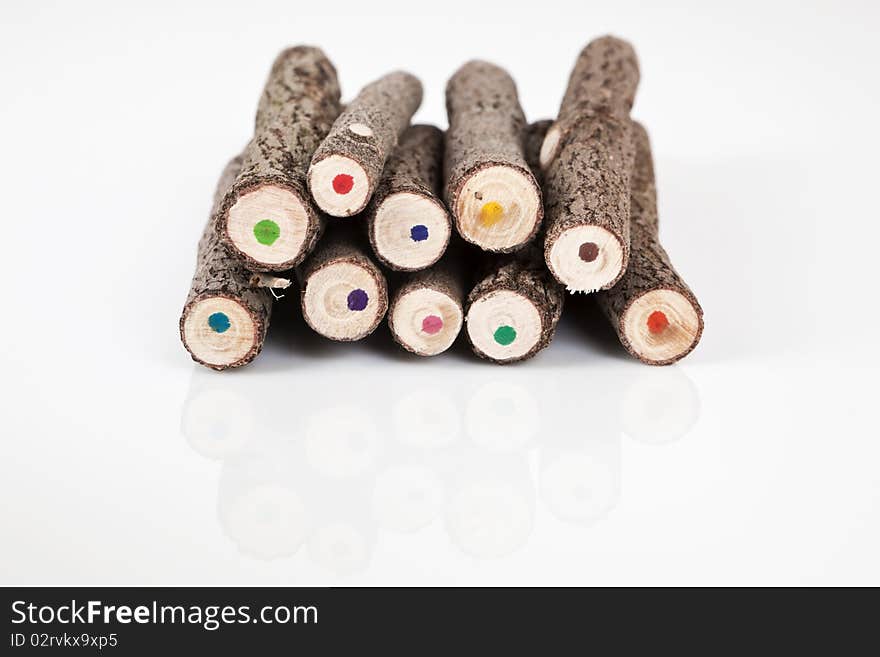 Coloured handmade original bark pencils on white background pointing with the back to the camera. Coloured handmade original bark pencils on white background pointing with the back to the camera.