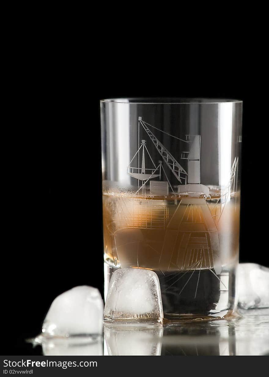 The photo shows a glass filled with whiskey and some ice cubes