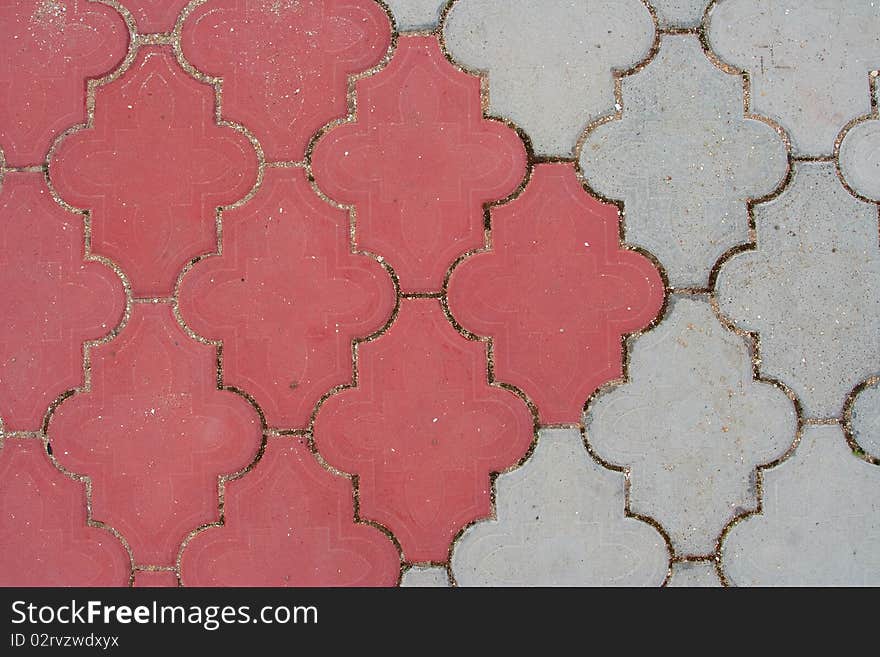 Pedestrian trail paved with red and gray stone tiles. Texture, background. Pedestrian trail paved with red and gray stone tiles. Texture, background