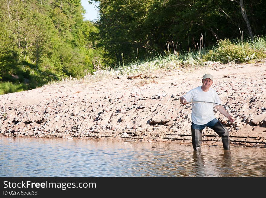 Senior fisherman fishing on a river. Senior fisherman fishing on a river