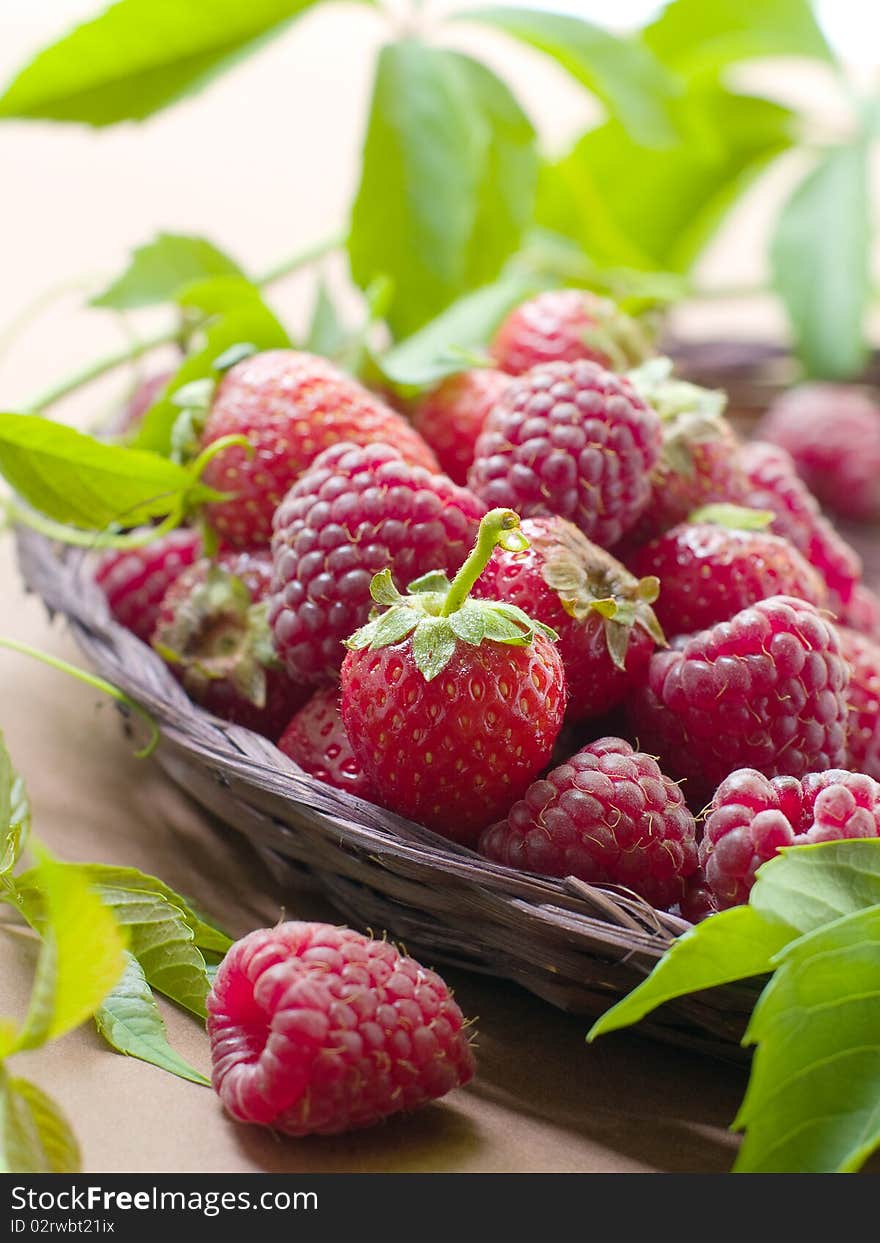 Fresh, ripe raspberries and strawberries in little wooden berry baskets. Fresh, ripe raspberries and strawberries in little wooden berry baskets.