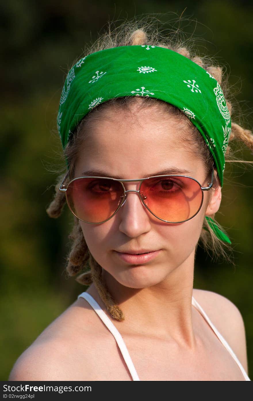 Young hippie woman  in a green  headscarf and sunglasses. Young hippie woman  in a green  headscarf and sunglasses