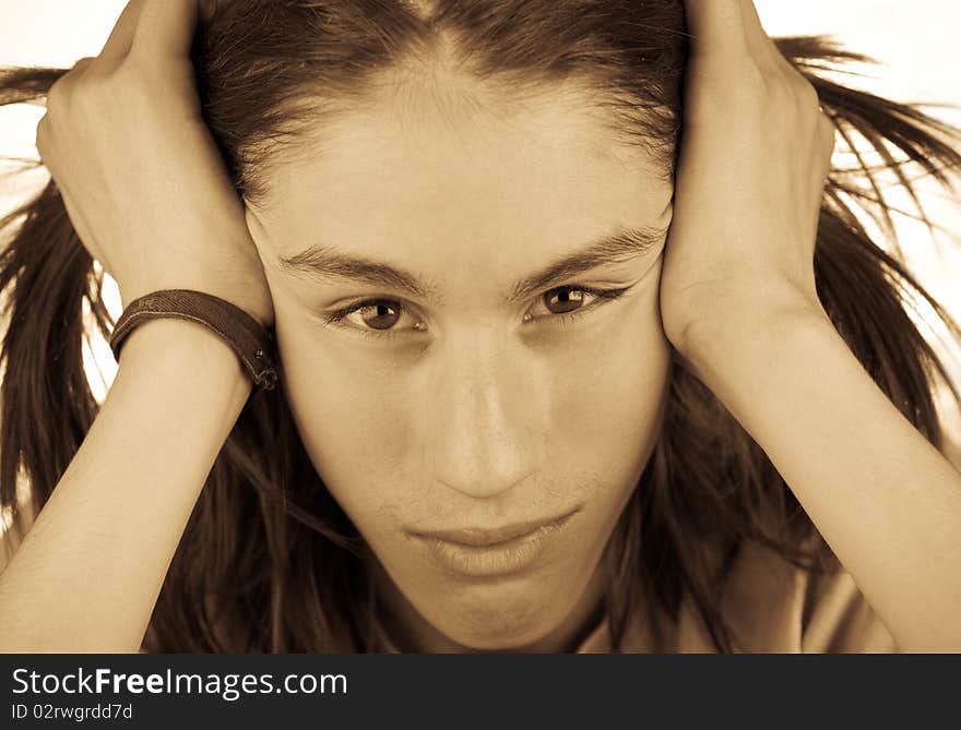 Monochrome portrait of a attractive teenager with shaggy hair, head in hands.