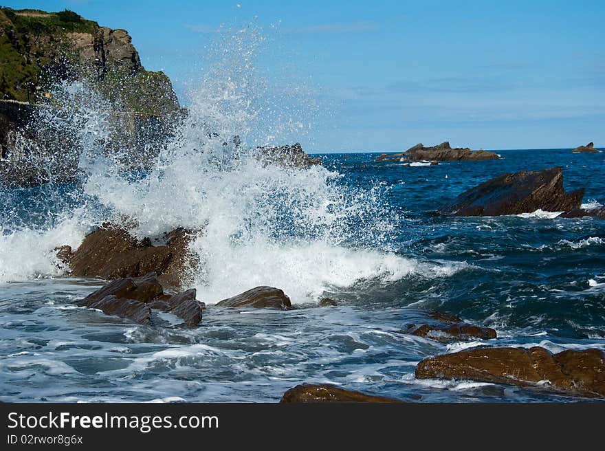 Waves breaking over rocks by the shore. Waves breaking over rocks by the shore