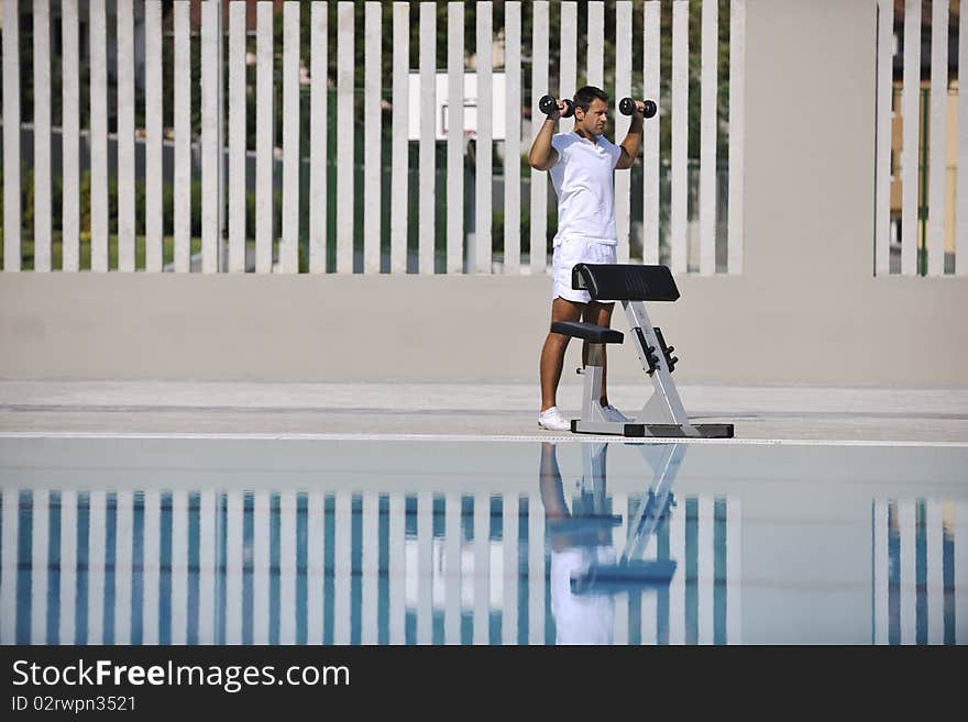 Young healthy athlete man exercise at poolside