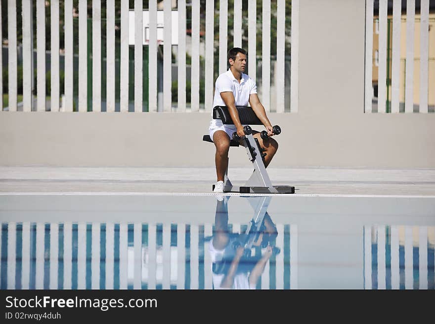 Young healthy athlete man exercise at poolside. Young healthy athlete man exercise at poolside