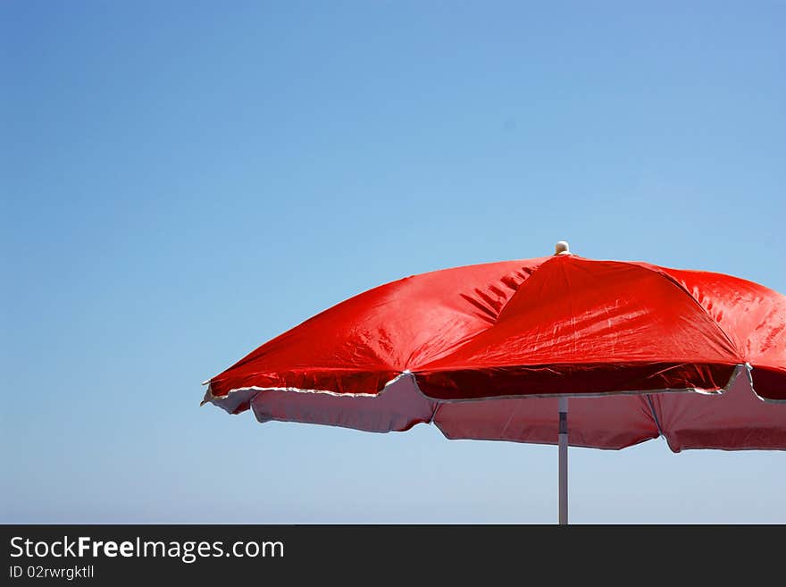 Beach umbrella on the blue sky background