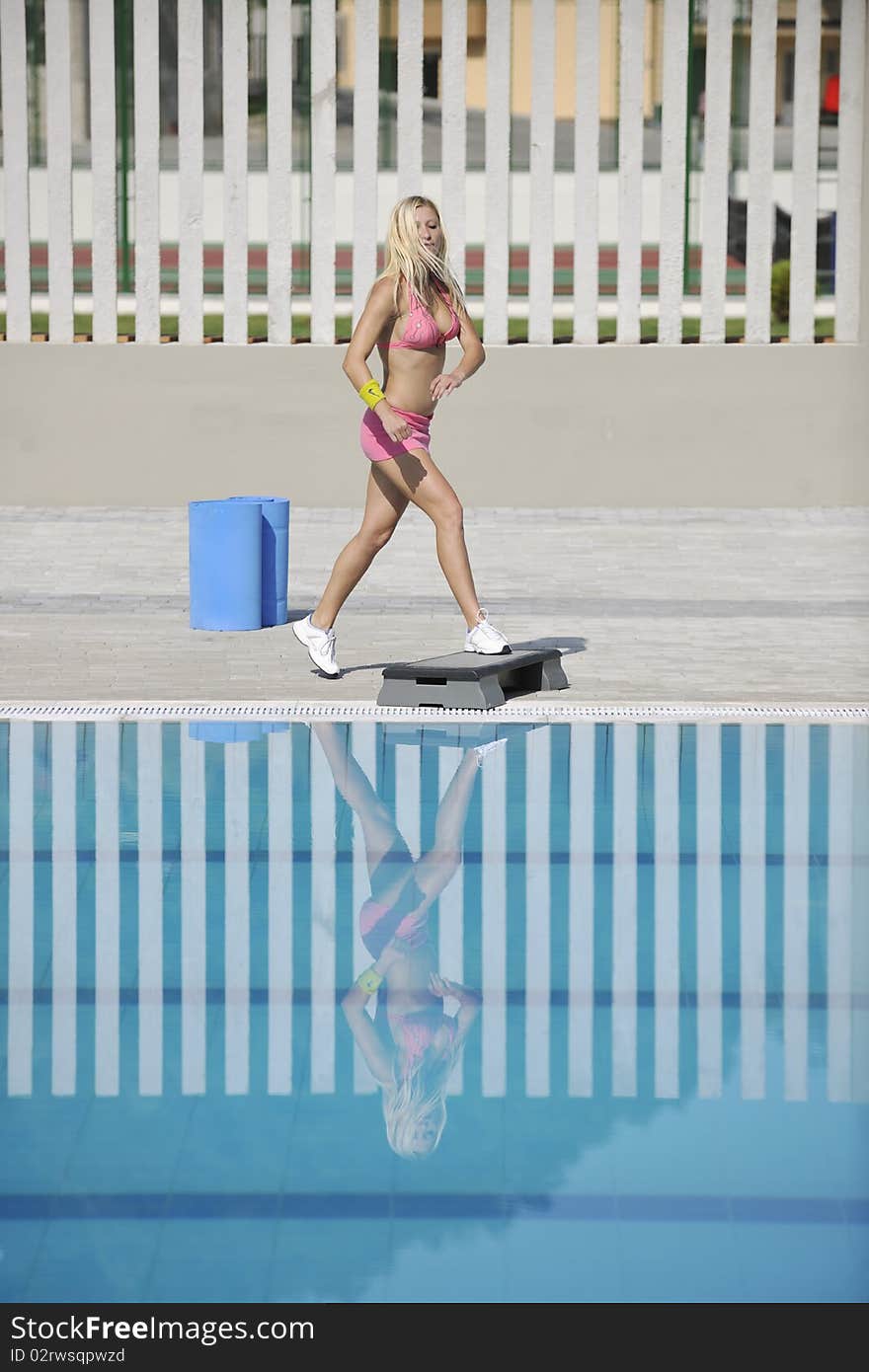 Young beautiful healthy woman exercise fitness and stepping at swimming pool. Young beautiful healthy woman exercise fitness and stepping at swimming pool