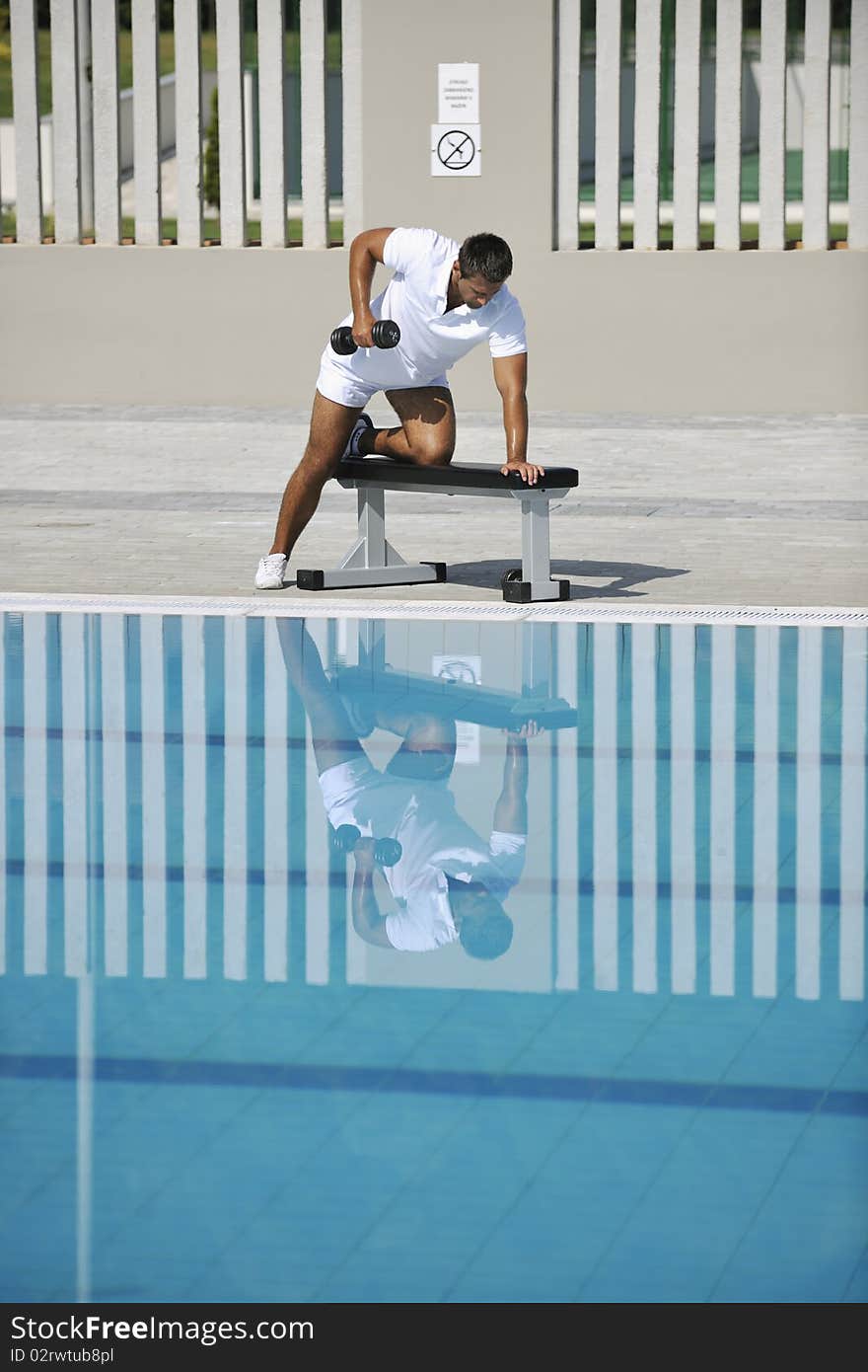 Young healthy athlete man exercise at poolside. Young healthy athlete man exercise at poolside