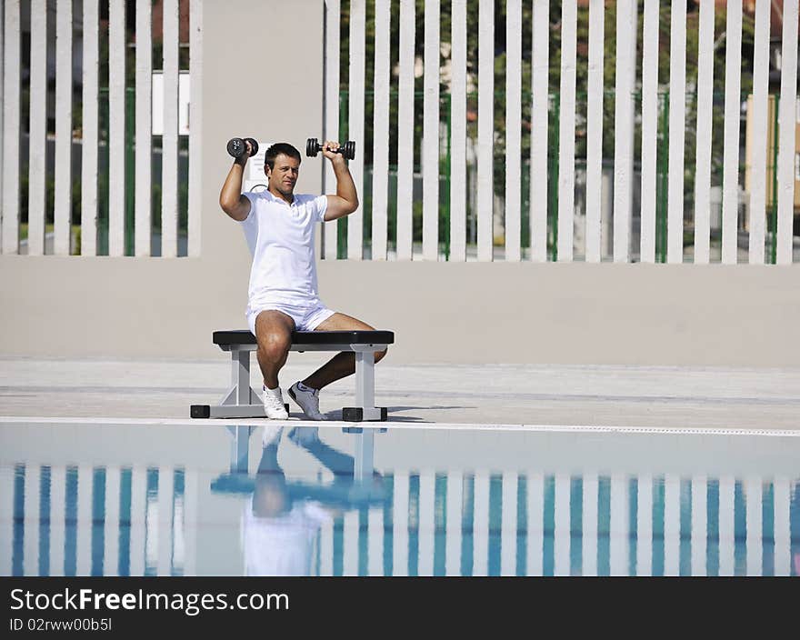 Young healthy athlete man exercise at poolside. Young healthy athlete man exercise at poolside