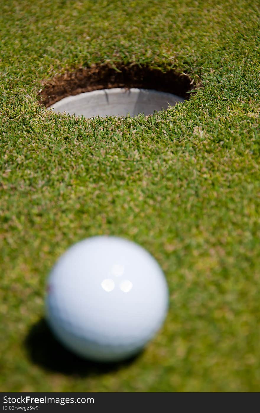 Golf hole with ball in the green