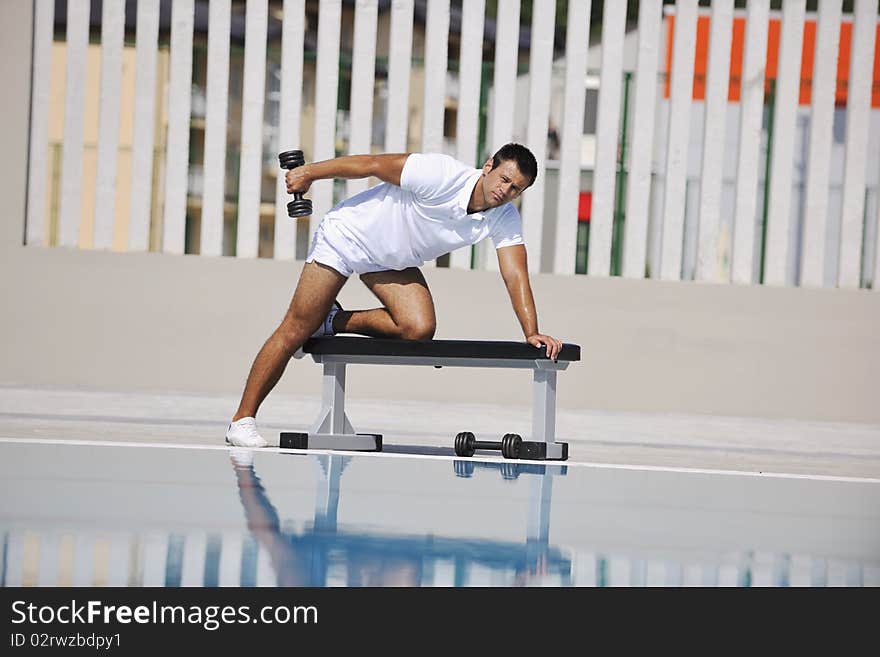 Young healthy athlete man exercise at poolside. Young healthy athlete man exercise at poolside