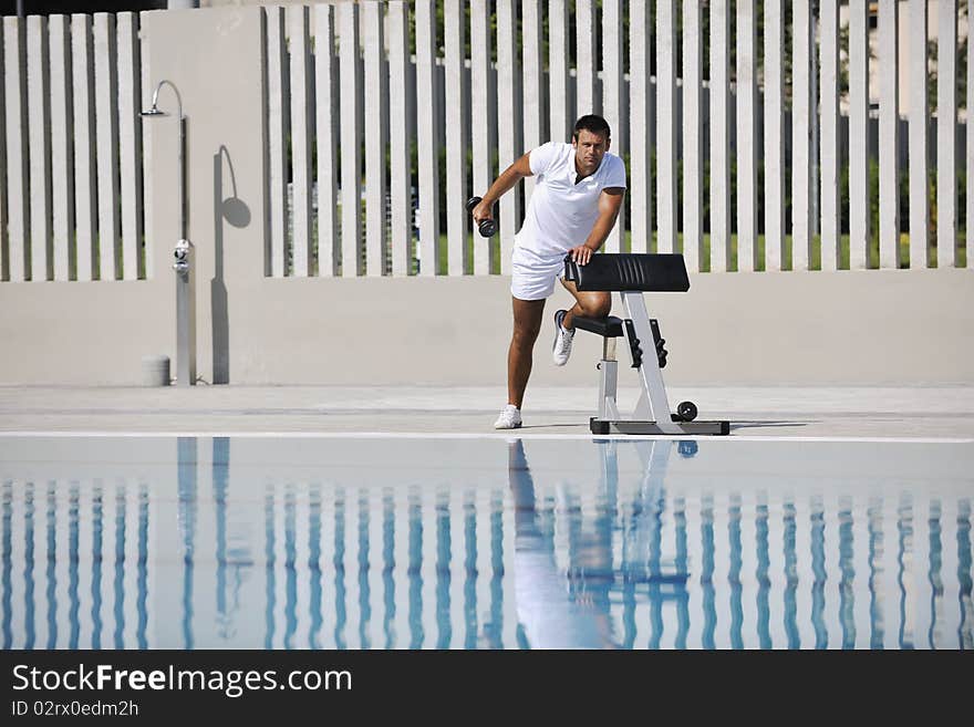 Young healthy athlete man exercise at poolside. Young healthy athlete man exercise at poolside