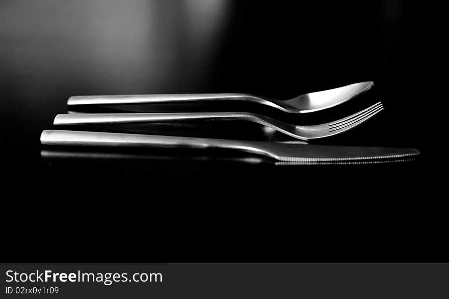 Silverware on black table (shallow DOF, focus on fork)