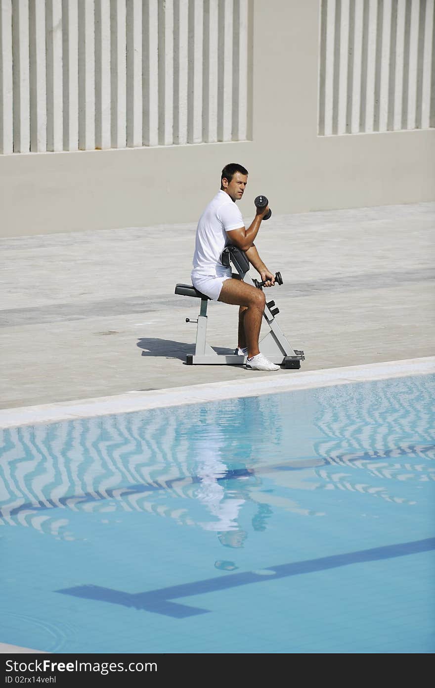 Young healthy athlete man exercise at poolside. Young healthy athlete man exercise at poolside