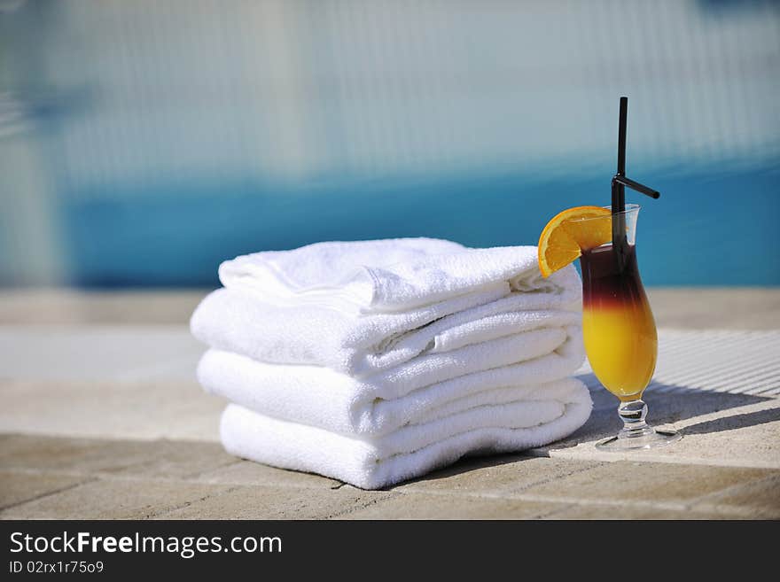 Coctail dring with orange att sunny day on swimming pool side with white towel decoraton. Coctail dring with orange att sunny day on swimming pool side with white towel decoraton