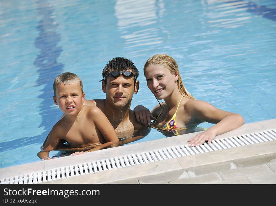 Happy young family have fun on swimming pool at summer vacation