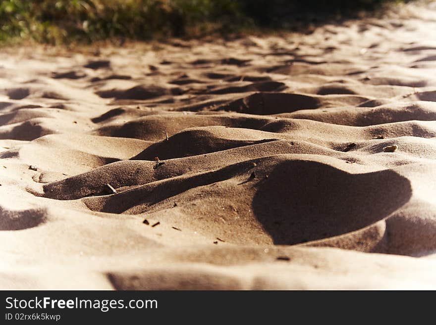 Sand and beautiful shades on it.Yellow sea sand. A beach sand.