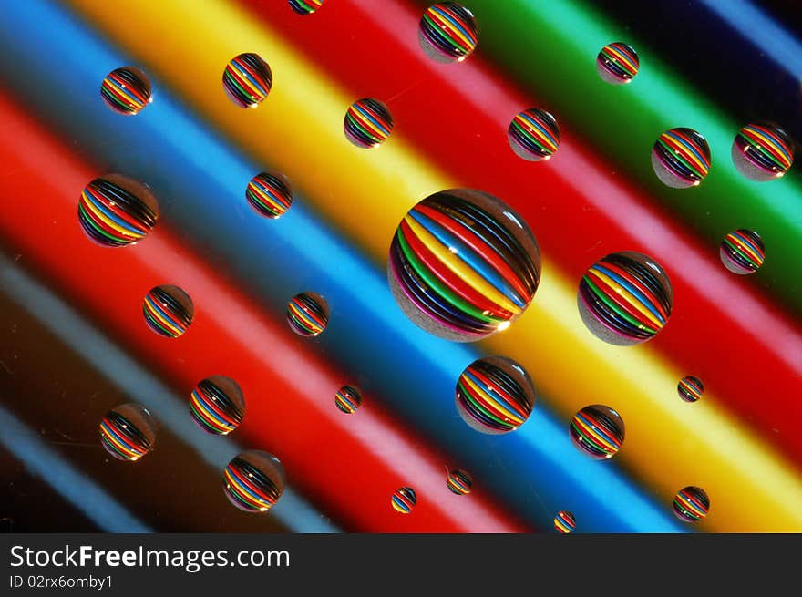 This is a refraction in the water. The water drops are on a piece of glass suspended a foot or so above colored pencils. This is a refraction in the water. The water drops are on a piece of glass suspended a foot or so above colored pencils.