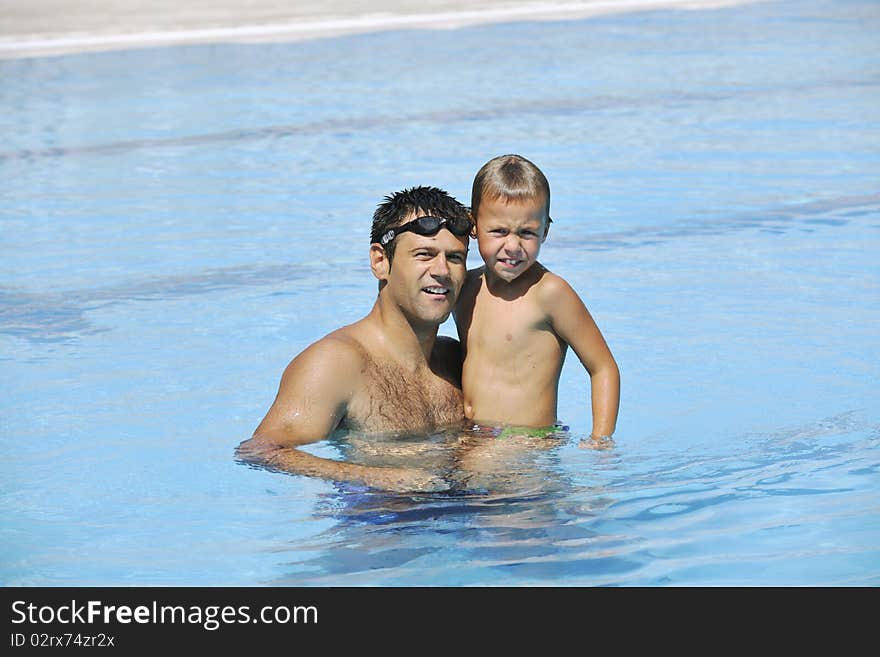 Happy father and son at swimming pool