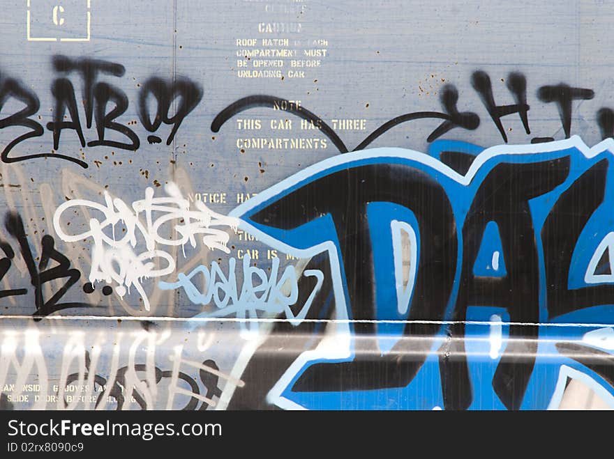 Section of tag words spray-painted on metal panel of rail car. Section of tag words spray-painted on metal panel of rail car.