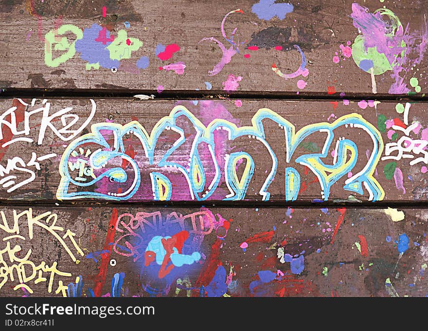 Close-up of picnic table decorated with colorful graffiti in paint. Close-up of picnic table decorated with colorful graffiti in paint