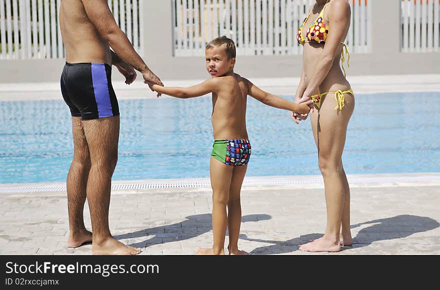 Happy young family have fun on swimming pool at summer vacation