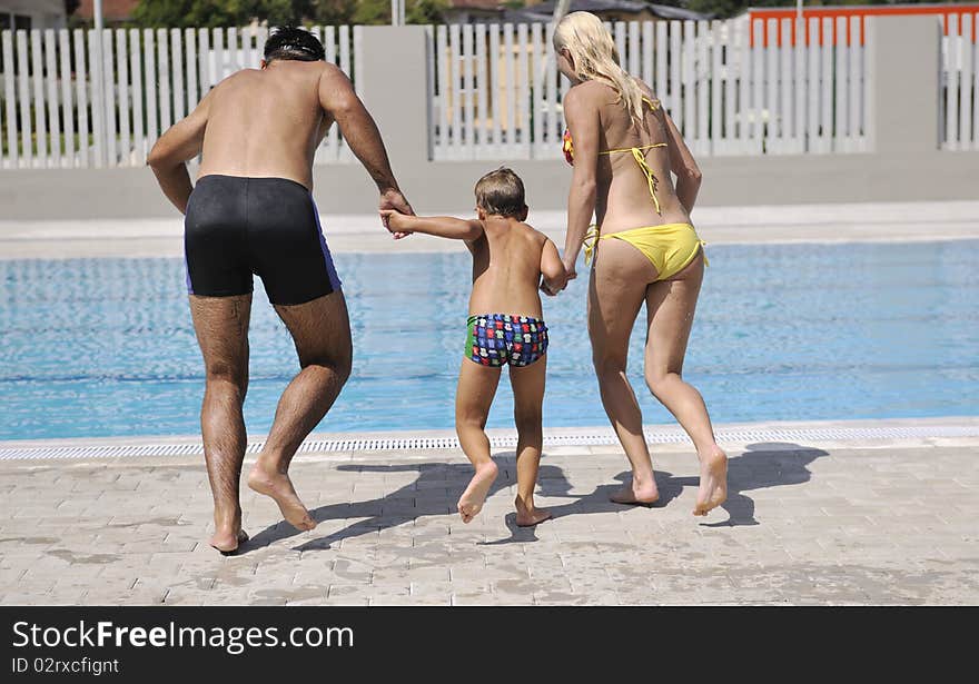 Happy young family have fun on swimming pool at summer vacation