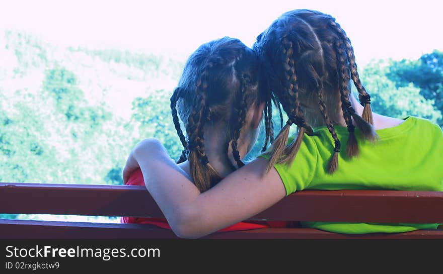 Sisters sitting on park bench