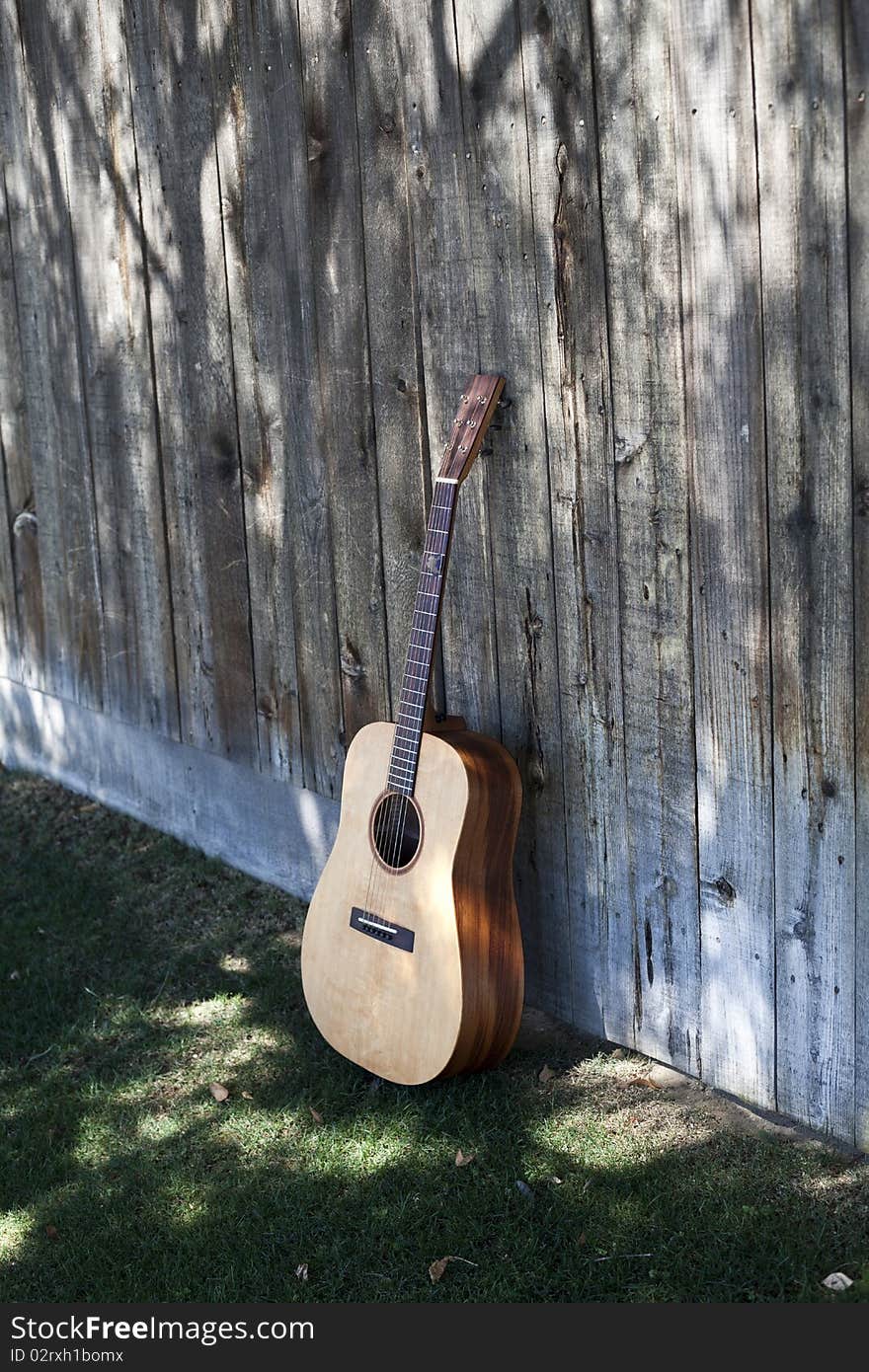 Guitar Resting On An Old Fence