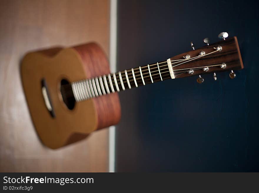 Acoustic Guitar Against a Wall