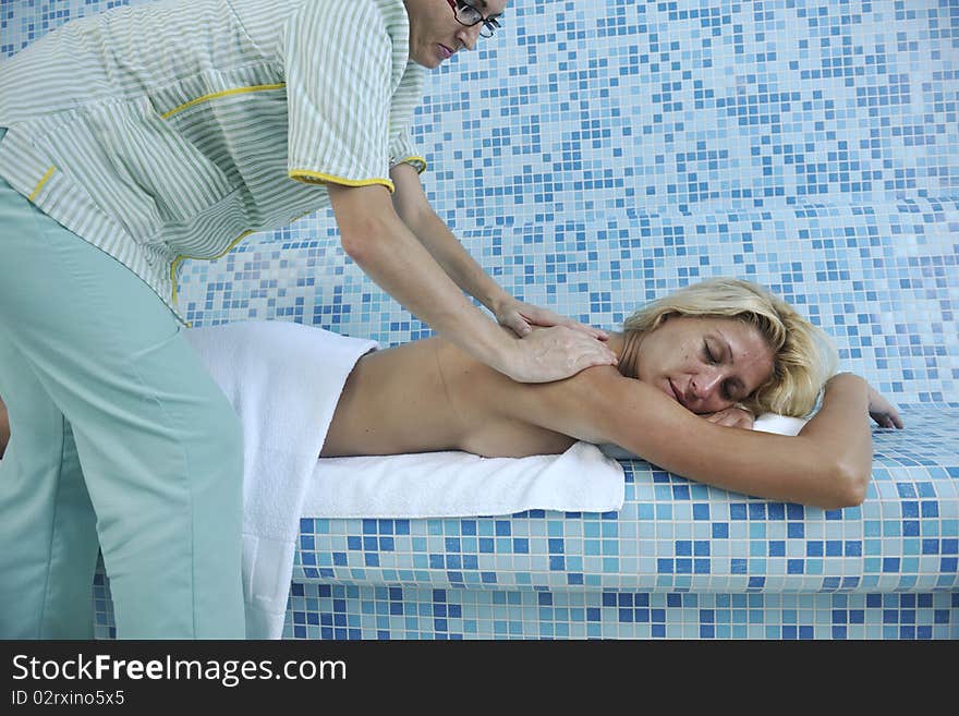 Hands massaging her back - A pretty woman getting a shoulder and back massage at spa and wellness center. Hands massaging her back - A pretty woman getting a shoulder and back massage at spa and wellness center