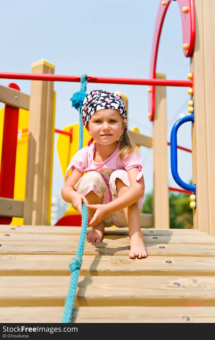 Pretty little girl on outdoor playground equipment. Pretty little girl on outdoor playground equipment