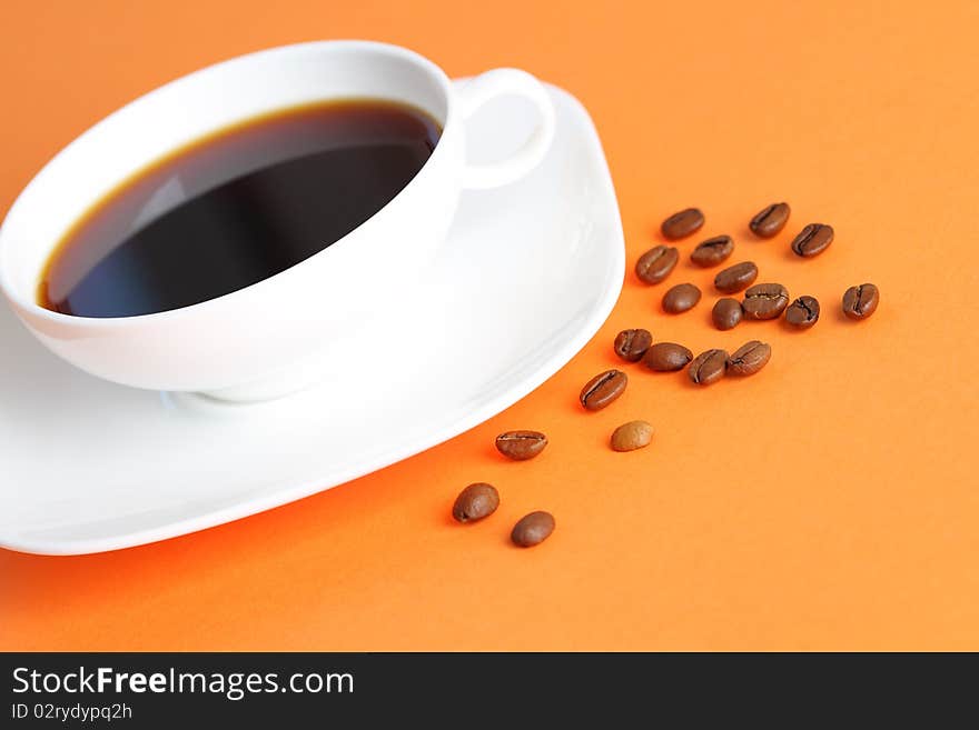 Cup of the coffee on the orange background