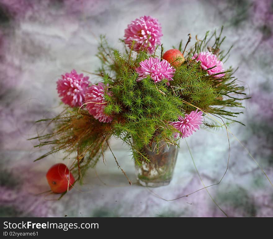 In glass moss and flowers of chrysanthemum stand an apple lies alongside. In glass moss and flowers of chrysanthemum stand an apple lies alongside