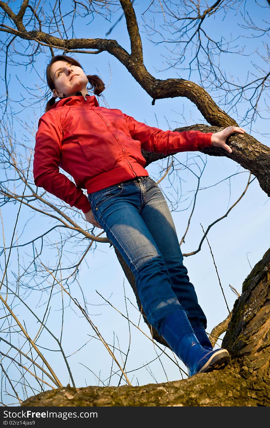 Girl standing on a dry tree, and looks forward