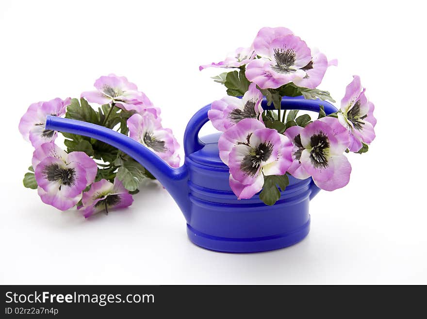 Blue plastic watering can with flower jewelry