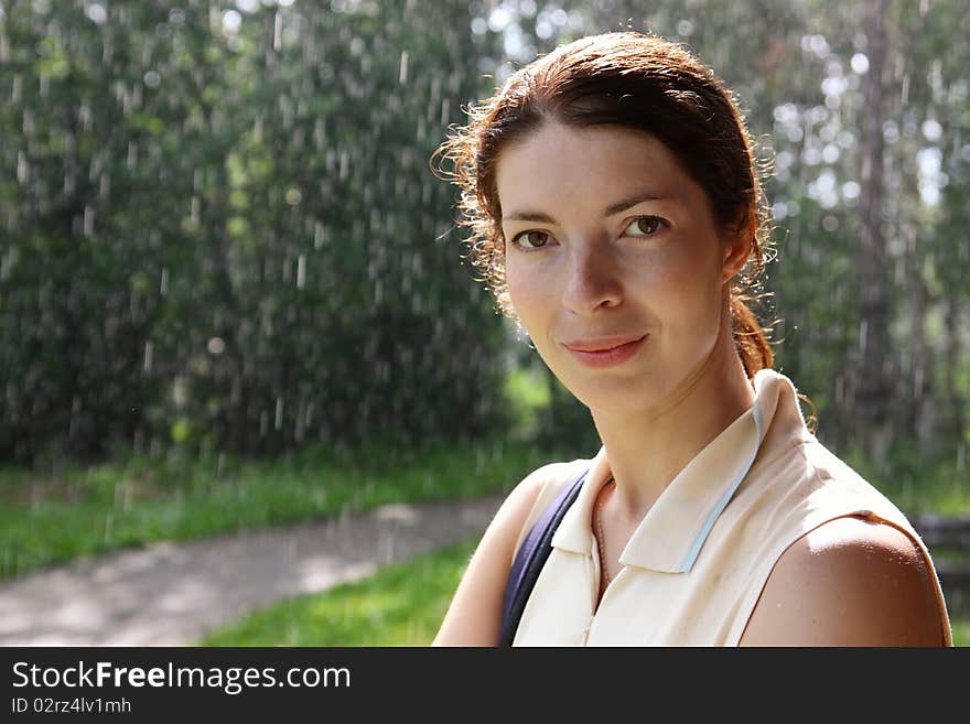 Portrait of a beautiful girl on the background of the ongoing rain