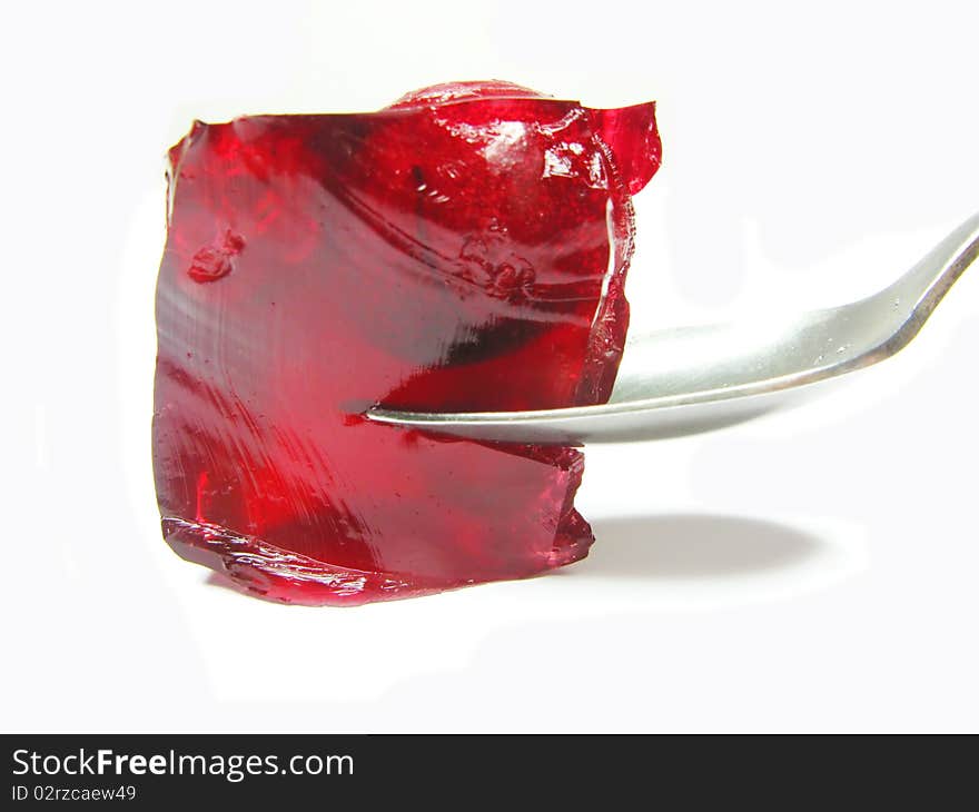 Red colored jelly marmalade with cherry and spoon inside