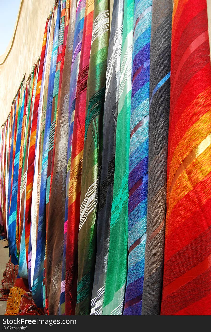 A display of rugs for sale on a wall in a market stall in Fes. A display of rugs for sale on a wall in a market stall in Fes