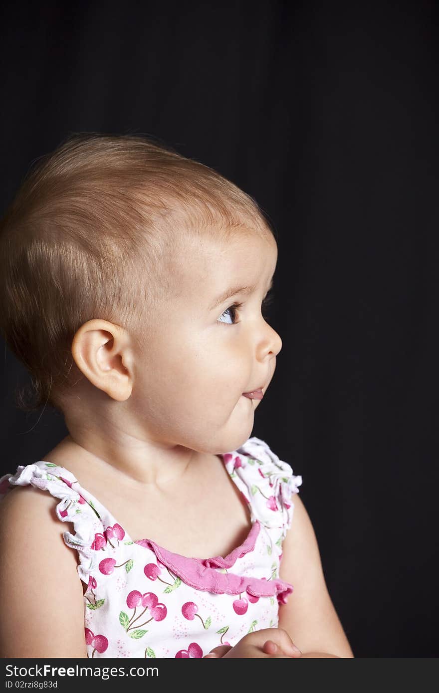 Baby girl looking to side with tongue out. Baby girl looking to side with tongue out.