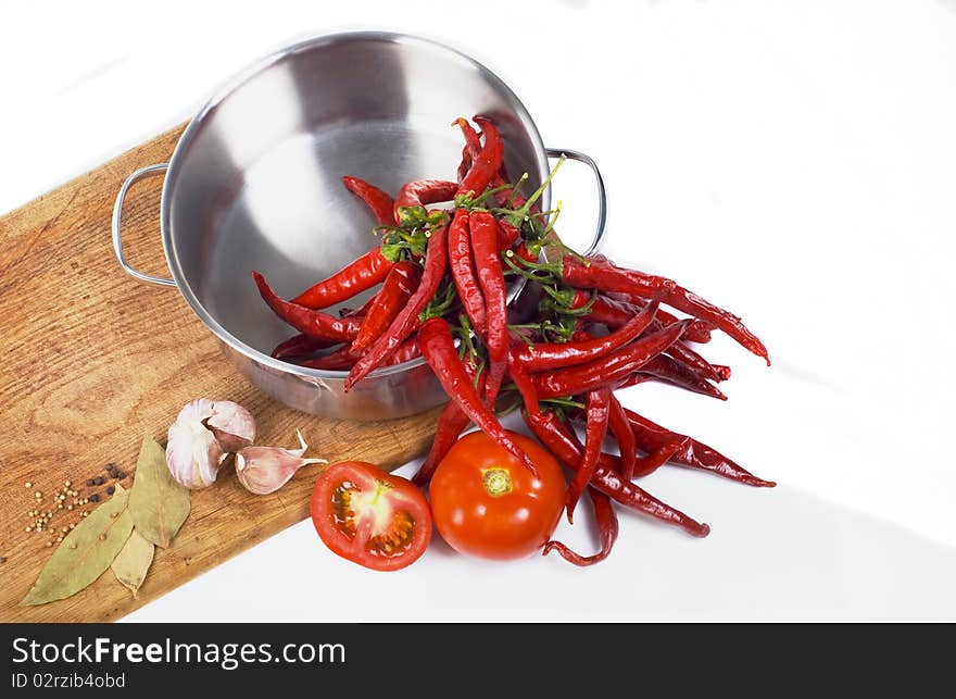 Pan, red pepper, garlic and spices on wooden board. Pan, red pepper, garlic and spices on wooden board