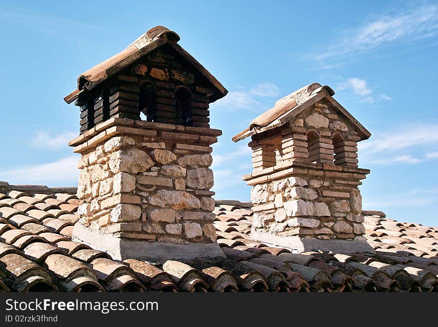 Two chimneys of stone and bricks in an italian house