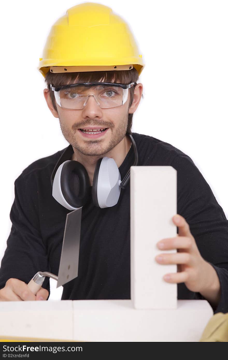 Happy construction worker with white brick and spade - isolated. Happy construction worker with white brick and spade - isolated