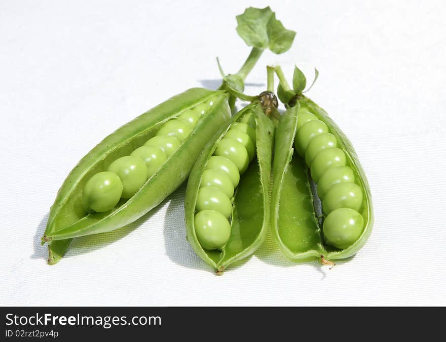 Pea pods open revealling fresh young green garden peas. Pea pods open revealling fresh young green garden peas.