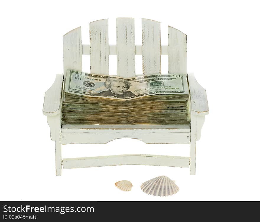 Big Stack of US Currency Twenty Dollar Bills lying in a miniature white adirondack chair with beach shells,  isolated on white background. Big Stack of US Currency Twenty Dollar Bills lying in a miniature white adirondack chair with beach shells,  isolated on white background.