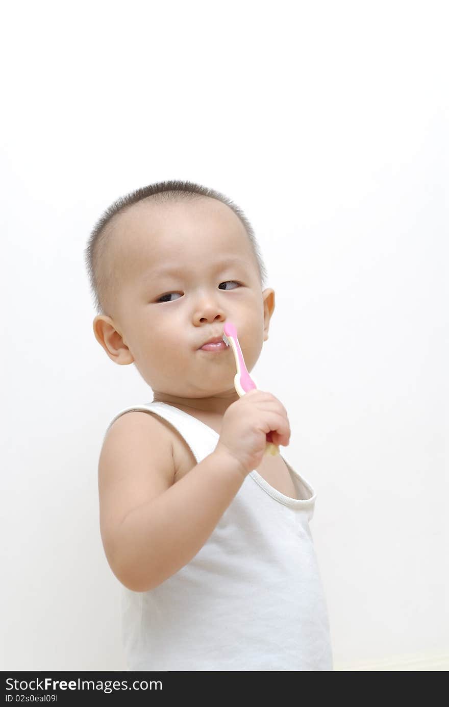 It is a cute chinese baby, he is brushing his teeth. isolated. It is a cute chinese baby, he is brushing his teeth. isolated