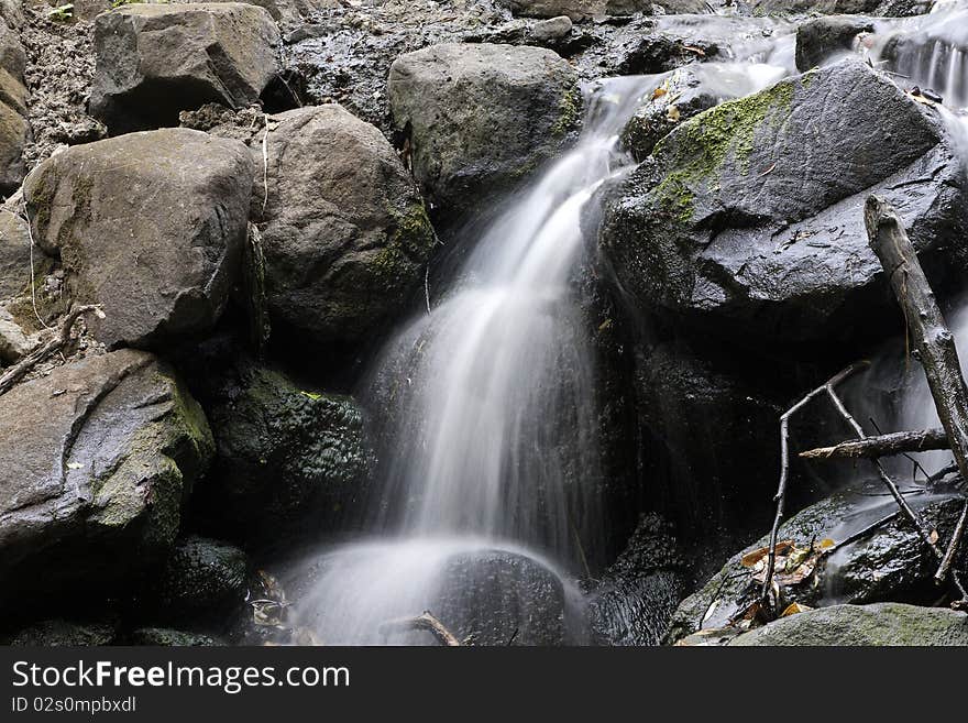 Water flows over rocks in small park stream. Water flows over rocks in small park stream