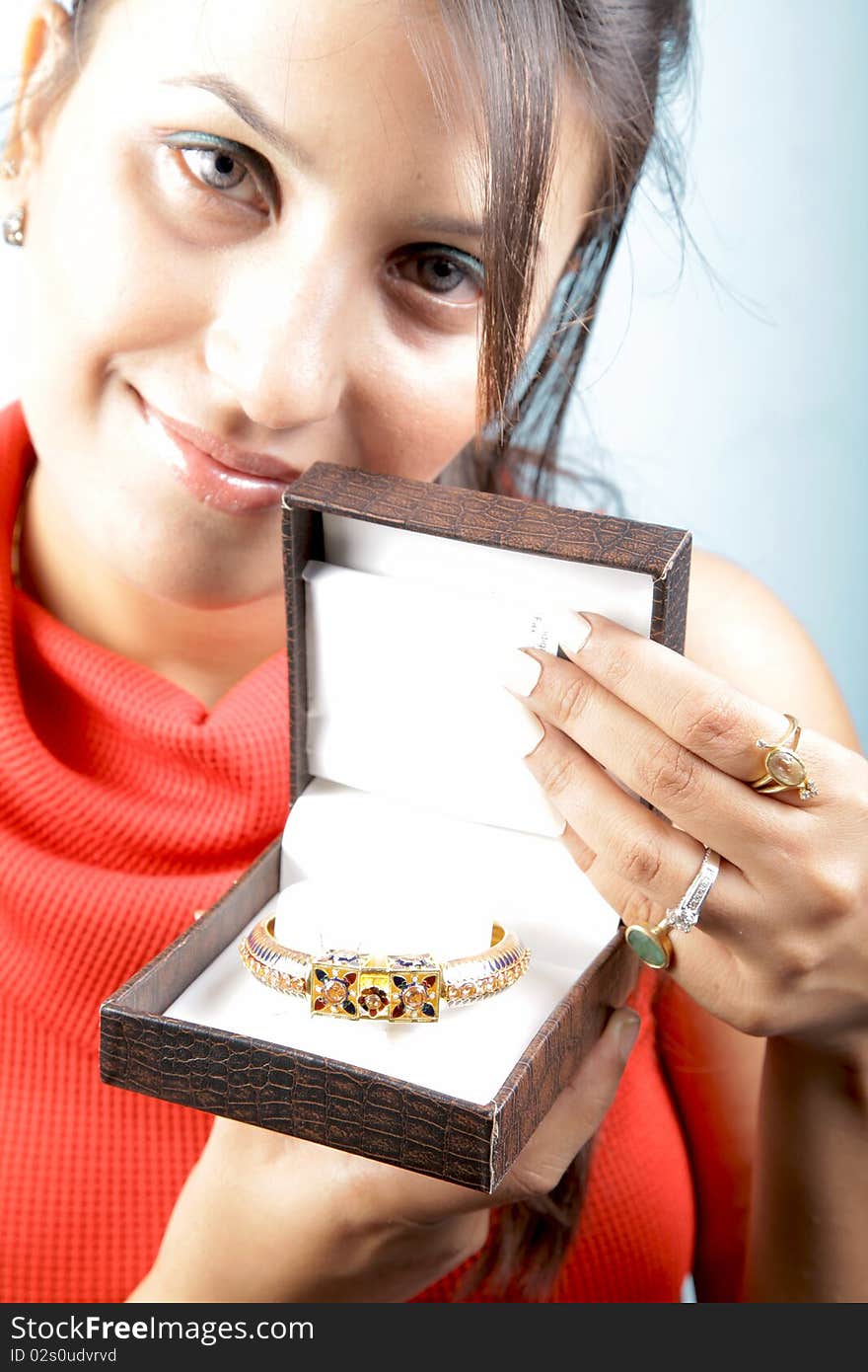 Girl holding golden bracelet jewellery with isolated background. Girl holding golden bracelet jewellery with isolated background.