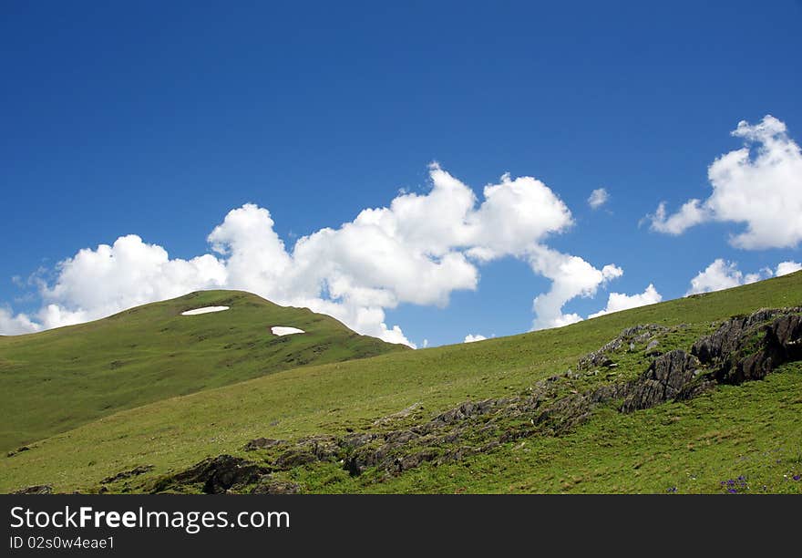 Green hills blue sky and white huge clouds